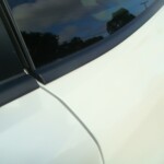 Before and after photographs of a damaged white Subaru that was repaired by Elite Paint & Body Shop in West Palm Beach, Florida